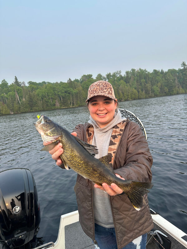 Angler holding a walleye caught at dawn on a northwoods lake