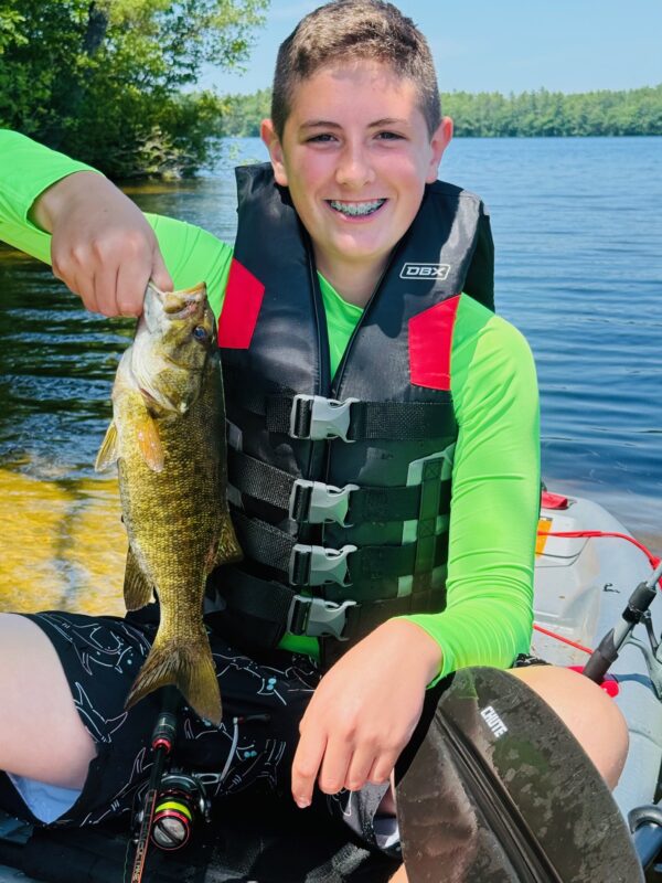 Teen angler in a kayak with a smallmouth bass